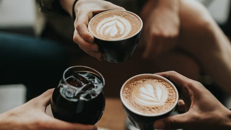 three person holding mug and glass with beverage inside