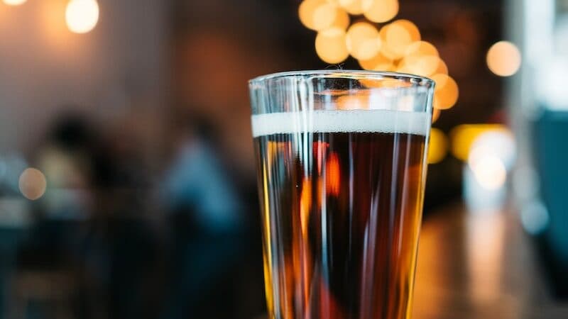clear glass drinking glass filled with beverage on table